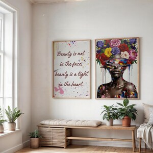 May include: Two framed art prints on a white wall. One has the text "Beauty is not in the face, beauty is a light in the heart." The other shows a woman with a floral headpiece. A wooden bench and potted plants are below.