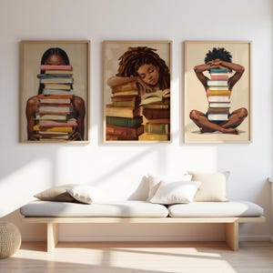 May include: Three framed art prints depicting illustrations of people with books. One shows a person with books obscuring their face, another shows a person resting on books, and the third shows a person with books in front of them.