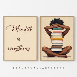 May include: Two framed art prints. One features the text "Mindset is everything" in brown script on a beige background. The other depicts a person with a stack of books on their back, arms covering their eyes.