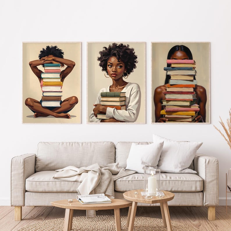 May include: Three framed art prints featuring illustrations of women with stacks of books. One print shows a woman sitting cross-legged with a book stack, another shows a woman holding books, and the third shows a woman with books covering her face.