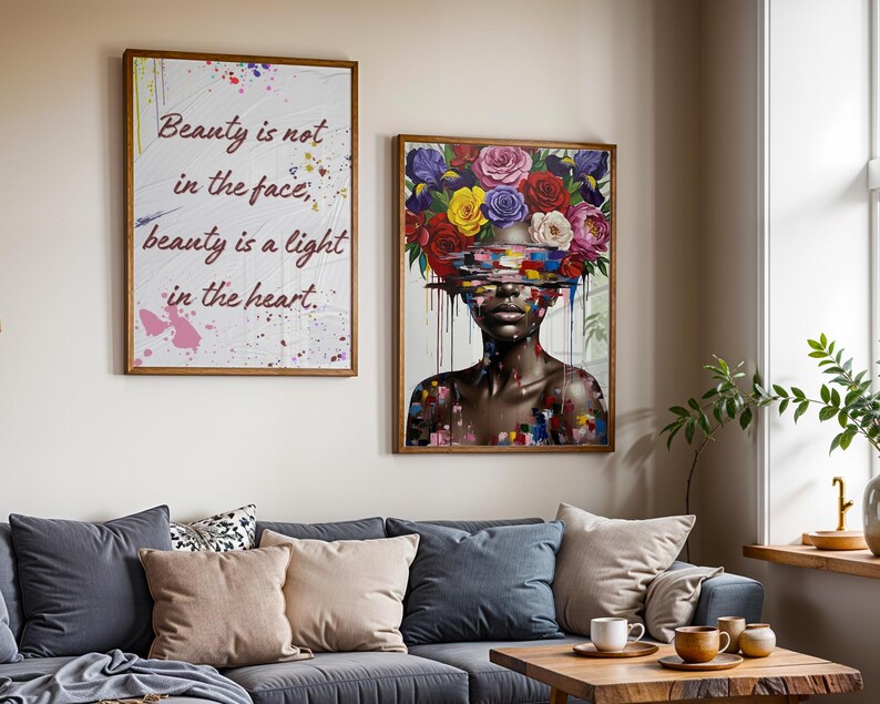 May include: Two framed art prints. One displays the text "Beauty is not in the face, beauty is a light in the heart." The other shows a woman with a floral headpiece. Both are in wooden frames and hang above a grey sofa with cushions.
