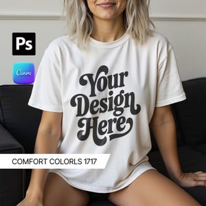 Pode incluir: Camiseta creme com o texto "Your Design Here" em uma fonte retrô arrojada. A camisa é no estilo Comfort Colors 1717. A imagem também inclui os logotipos do Photoshop e Canva.