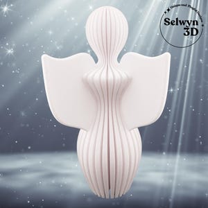Puede incluir: Una figura de &aacute;ngel blanca impresa en 3D con un dise&ntilde;o en capas. El &aacute;ngel tiene alas extendidas y una cabeza redondeada. El texto "Selwyn 3D" est&aacute; en un c&iacute;rculo en la esquina superior derecha, con las palabras "Unique and Playful Designs" encima.