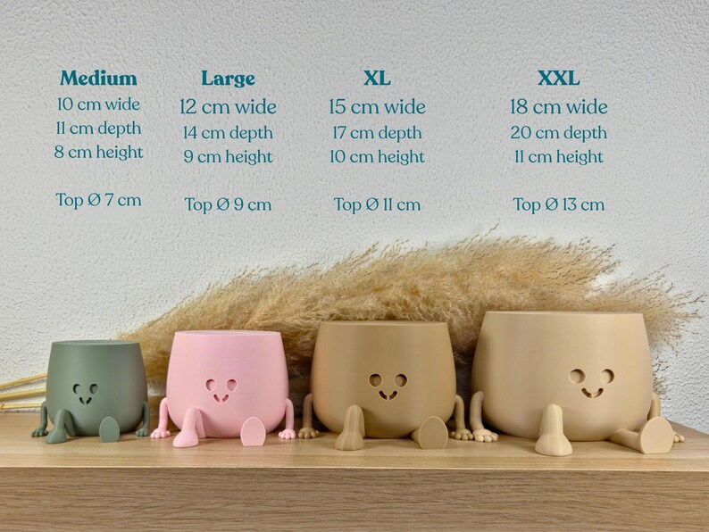 May include: Four matte-finish planters in sage green, light pink, tan, and beige, each featuring a smiling face cutout and two small legs. Text above lists sizes from Medium to XXL with dimensions in cm, including width, depth, height, and top diameter.