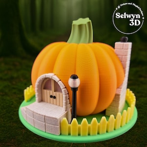 Può includere: Una casa a forma di zucca stampata in 3D con uno stelo verde, un camino e una piccola porta. La casa ha una staccionata gialla e un lampione nero. La base è verde e il testo "Selwyn 3D" è in alto a destra.