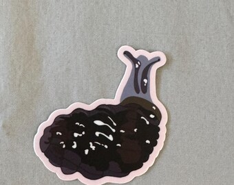 May include: A sticker featuring a stylized illustration of a slug. The slug is primarily dark brown and black, with white accents and a light pink border. The top portion is a lighter gray color.