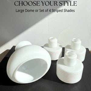 Può includere: Un grande paralume in vetro bianco a forma di cupola e un set di tre paralumi cilindrici in vetro bianco più piccoli con sottili strisce orizzontali rosse. Il testo recita: ONE LISTING • CHOOSE YOUR STYLE Large Dome or Set of 4 Striped Shades.