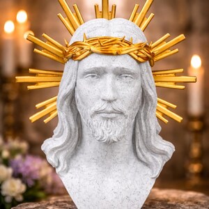 Könnte beinhalten: Eine Büste von Jesus Christus, mit einer goldenen Dornenkrone und einem goldenen Heiligenschein. Die Skulptur hat ein detailliertes Gesicht mit Bart und langem Haar. Die Büste besteht aus einem hellgrauen, steinartigen Material.