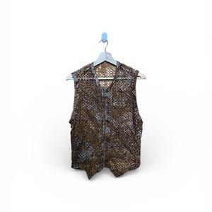May include: A brown, open-weave vest with a zipper closure, hanging on a wooden hanger. The vest has a textured, patterned design and a V-neck. The garment is displayed against a white background.