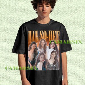 Könnte beinhalten: Schwarzes T-Shirt mit einem goldenen Schriftzug "HAN SO-HEE" über einer Collage von sechs Frauen. Das T-Shirt wird von einer Person mit dunklem, lockigem Haar getragen.