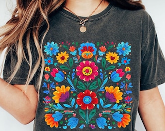 Op de afbeelding: Donkergrijs t-shirt met een levendig bloemenontwerp in een vierkant patroon. Het ontwerp bevat kleurrijke bloemen in tinten rood, blauw, geel, oranje en paars. Het woord "PEPPER" staat linksonder in de afbeelding.