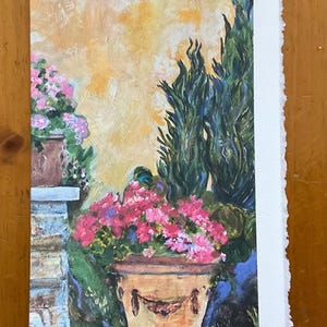 May include: A painting of a terracotta pot filled with pink flowers, set against a backdrop of a stone wall and a tall, dark green bush.