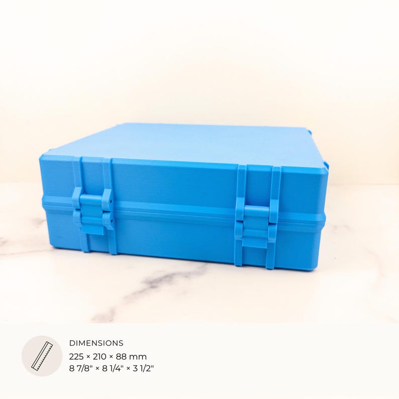 K&ouml;nnte beinhalten: Eine hellblaue rechteckige Box mit sicheren Verschl&uuml;ssen. Die Box misst 225 x 210 x 88 mm (8 7/8" x 8 1/4" x 3 1/2"). Sie ist zum Schutz des Inhalts konzipiert. Die Abmessungen sind auch in Zoll angegeben.