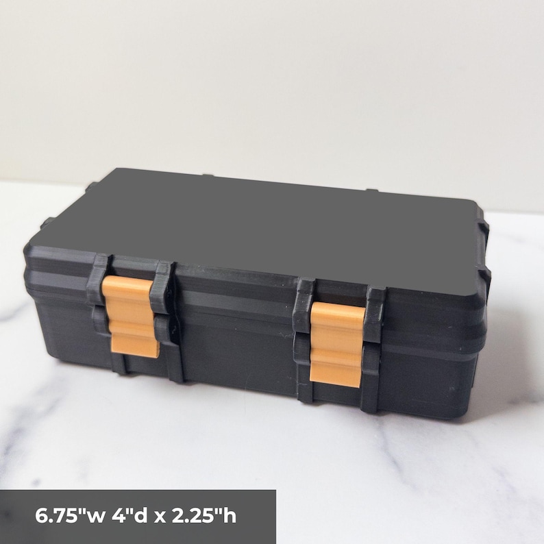 May include: A black rectangular storage case with two orange clasps. The case measures 6.75"w x 4"d x 2.25"h. The case is made of a durable material and is designed to protect the contents inside.