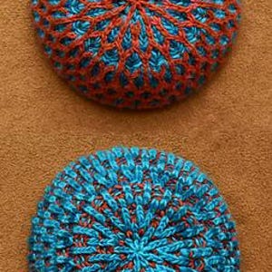 May include: Two knitted hats, one blue and one orange, with a textured pattern. The hats are round and have a pointed top.