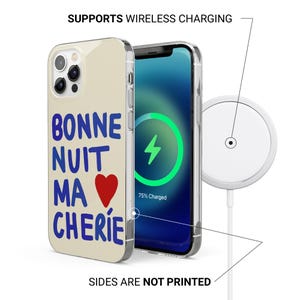 Puede incluir: Una funda de tel&eacute;fono con las palabras "BONNE NUIT MA CH&Eacute;RIE" en azul, un coraz&oacute;n rojo y un borde transparente. La pantalla del tel&eacute;fono muestra un s&iacute;mbolo de carga verde. Tambi&eacute;n se muestra un cargador inal&aacute;mbrico blanco.