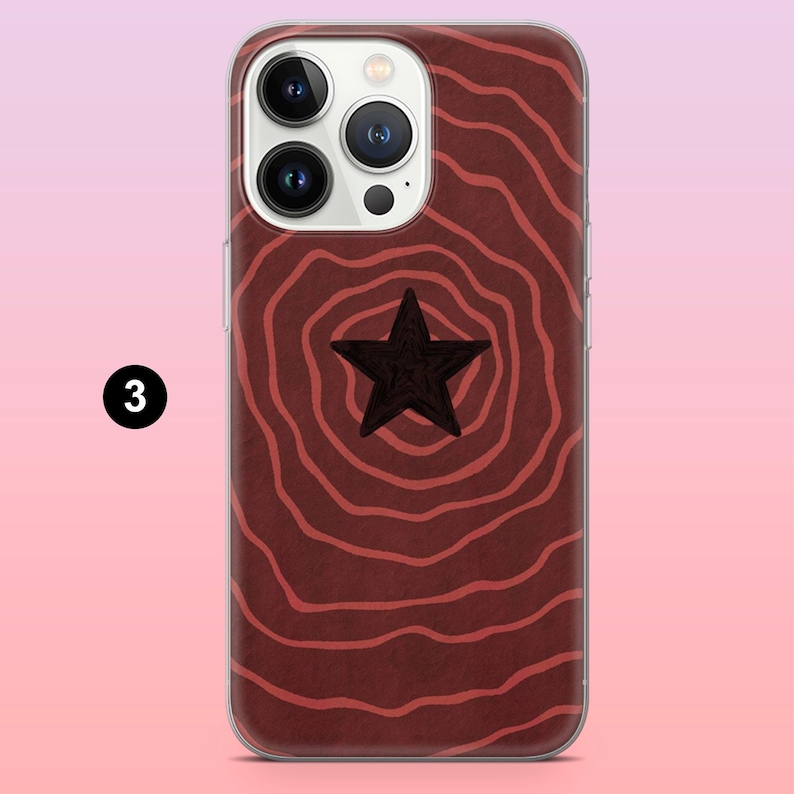 Op de afbeelding: Telefoonhoesje met een donkerrood houtnerfdesign en een zwarte ster in het midden. De hoes heeft een transparante rand en het nummer 3 in een witte cirkel.