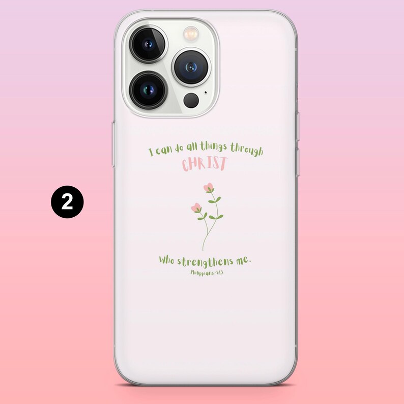 May include: White phone case with a floral design and the text "I can do all things through CHRIST Who strengthens me. Philippians 4:13" in green and pink. The case has a clear border and a pink and white gradient background.