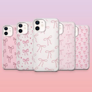 Op de afbeelding: Vijf telefoonhoesjes met een roze strikpatroon. De hoesjes hebben een transparante achtergrond met een herhalend ontwerp van roze strikken. Sommige hoesjes hebben een roze achtergrond met witte strikken en hartjes.