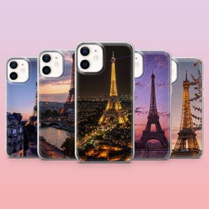 Op de afbeelding: Een verzameling van vijf telefoonhoesjes met de Eiffeltoren in verschillende omgevingen. De hoesjes tonen de toren bij zonsondergang, nacht en dag. De hoesjes hebben een heldere, glanzende afwerking en zijn geplaatst tegen een roze gradiënt achtergrond.