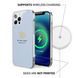 May include: A light blue phone case with a star graphic and the text "BE THE LIGHT Matthew 5:14-16". The phone screen displays a charging symbol. A white wireless charger is also shown.