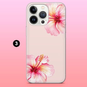 May include: A phone case with a pink hibiscus flower design. The case has a light pink background and features two watercolor-style hibiscus flowers in shades of pink and yellow. The phone case has a clear border.
