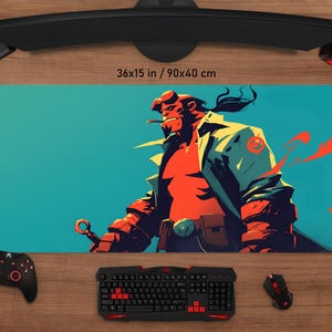 May include: A rectangular desk mat featuring a stylized illustration of Hellboy in shades of red, orange, and blue. The mat measures 36x15 inches (90x40 cm) and is surrounded by computer peripherals, including a keyboard, mouse, and controller.