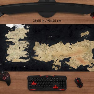 May include: A large black and tan map-themed gaming mouse pad, measuring 36 x 15 inches. The pad features a detailed map design with a black background. A keyboard, mouse, and controller are visible.