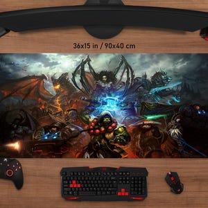 Könnte beinhalten: Großes rechteckiges Gaming-Mauspad mit einer Fantasy-Kampfszene. Es misst 90x40 cm und hat einen schwarzen Rand. Eine Tastatur, eine Maus und ein Controller sind ebenfalls sichtbar.