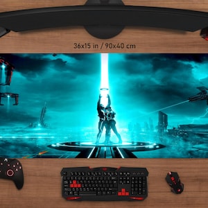 May include: A large gaming mouse mat with a futuristic sci-fi scene in shades of blue and teal. The mat measures 90x40 cm (36x15 in) and features a couple standing under a beam of light. A keyboard, mouse, and controller are visible.