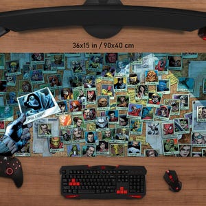 May include: A large rectangular mouse pad featuring a collage of comic book character images. The pad measures 36x15 inches. A hand holds a photo with the text "MOON KNIGHT". A keyboard, mouse, and game controller are also visible.