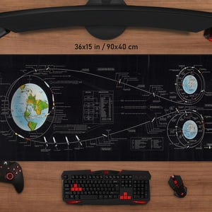 Puede incluir: Alfombrilla de ratón para juegos negra con un diagrama detallado de la Tierra y órbitas celestes, de 90x40 cm. La alfombrilla presenta un mapa del mundo e ilustraciones técnicas en blanco. Se ven un teclado, un ratón y un mando.
