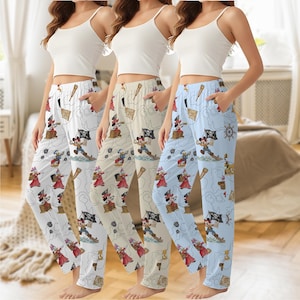 May include: Three pairs of pajama trousers in white, beige, and light blue, each with a repeating pirate-themed cartoon print. The trousers have a relaxed fit with a drawstring waist and pockets. The cartoon print includes pirate characters, treasure maps, and pirate ships.