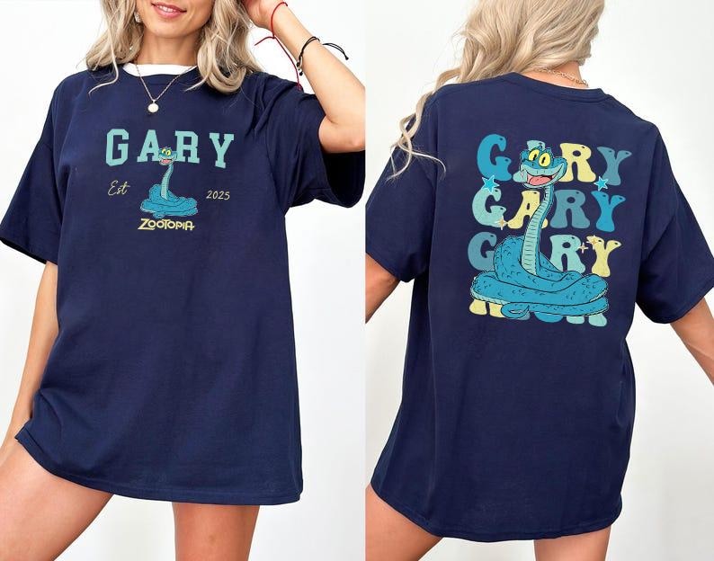 Peut inclure: T-shirt bleu marine avec un personnage de serpent de dessin anim&eacute; nomm&eacute; Gary de Zootopie. Le devant affiche "GARY" au-dessus du dessin du serpent, avec "Est 2025" et "ZOOTOPIA" en dessous. Le dos r&eacute;p&egrave;te "GARY" trois fois.