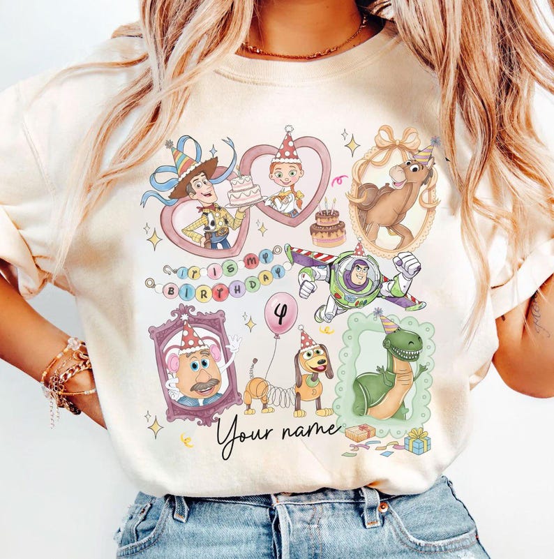 May include: Cream-colored t-shirt featuring colorful illustrations of Toy Story characters, including Woody, Buzz Lightyear, and others, with a "Happy Birthday" theme. The design includes a number "4" balloon and the text "Your name".
