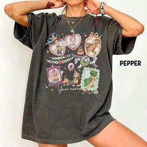 May include: Dark gray t-shirt featuring cartoon characters in heart-shaped frames, a birthday cake, and the text "Your name". The shirt also has the number 4 and the word "Pepper" printed on it.