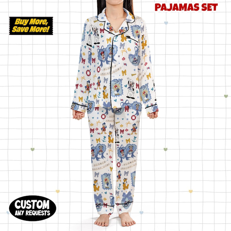 Puede incluir: Un conjunto de pijama blanco con estampado de personajes de dibujos animados, con una camisa con cuello abotonada y pantalones a juego. El conjunto tiene ribetes negros y el texto "PAJAMAS SET" es visible. La imagen tambi&eacute;n incluye el texto "Buy More, Save More!" y "CUSTOM ANY REQUESTS".