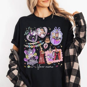 Op de afbeelding: Zwart T-shirt met kleurrijke illustraties van stripfiguren in kaders, met de tekst "It's my birthday" en het nummer "4". Het shirt bevat ook de tekst "Your name".