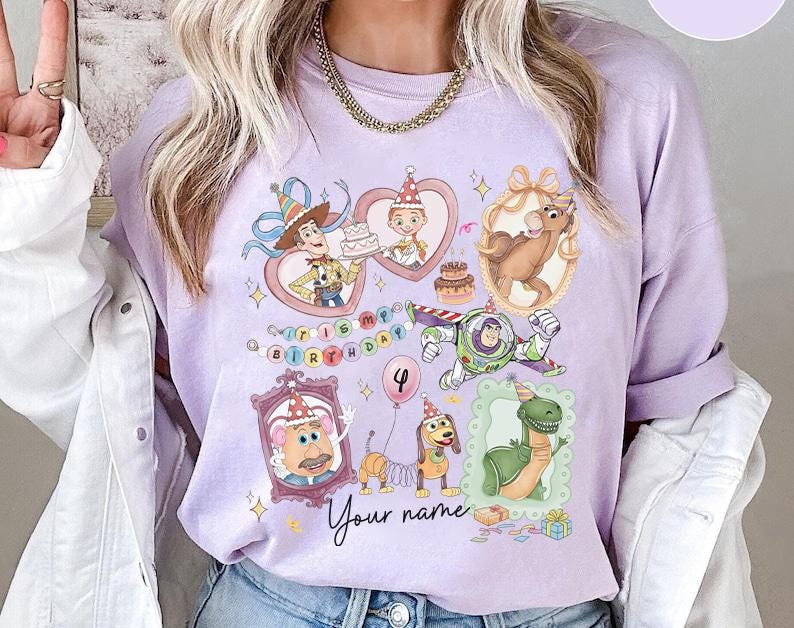 May include: A light purple long-sleeve shirt featuring cartoon characters from a popular animated movie. The design includes images of Woody, Buzz Lightyear, and other characters, with the text "Happy Birthday" and "Your name".