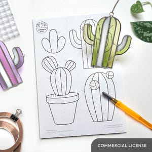 Op de afbeelding: Een zwart-witte lijntekening van een cactus met genummerde secties. De tekening staat op een wit vel papier met de tekst "greenery glass" in een cirkel bovenaan. De tekening is voor een glas-in-loodproject.
