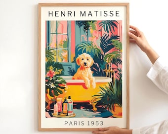 May include: A framed art print depicting a dog in a yellow bathtub, inspired by Henri Matisse. The artwork features a colourful interior with abundant greenery and the text "HENRI MATISSE PARIS 1953". The print is held by a person.
