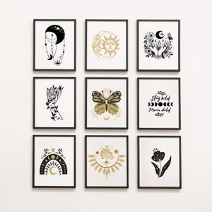 Op de afbeelding: Negen ingelijste kunstdrukken met hemelse en botanische ontwerpen. De prints bevatten zwart-gouden illustraties van manen, zonnen, handen, vlinders en bloemelementen. E&eacute;n print bevat de tekst "Stay Wild Moon Child".