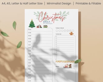 May include: A white Daily Christmas Planner with a minimalist design. The planner includes sections for the daily schedule, to-do list, and notes. The top of the planner features the text "Daily Christmas Planner" and festive illustrations.