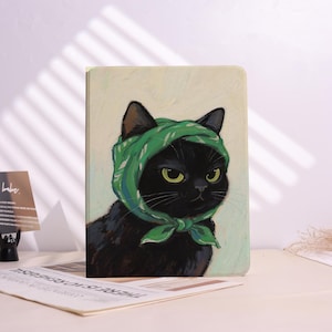 May include: A black cat wearing a green headscarf is the subject of this artwork. The cat has yellow eyes and is set against a light yellow background. The cat's fur is black, and the headscarf is green with a floral pattern.