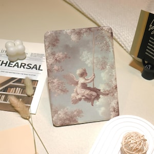 May include: A rectangular tablet case featuring a classical painting of an angel on a swing amidst a soft, cloudy sky and flowering trees. The color palette includes soft pinks, whites, and blues, creating a vintage aesthetic.