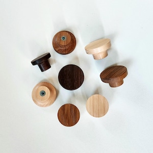 Puede incluir: Una taza de cerámica blanca con un asa negra y el texto "But First, Coffee" en negro, con una fuente de estilo manuscrito. La taza está sobre una superficie blanca.