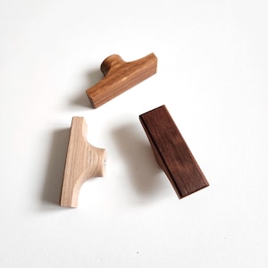 Puede incluir: Una taza de cerámica blanca con un asa negra y el texto "But First, Coffee" en negro y negrita. La taza está sobre una superficie blanca. La taza mide aproximadamente 10 cm de alto.