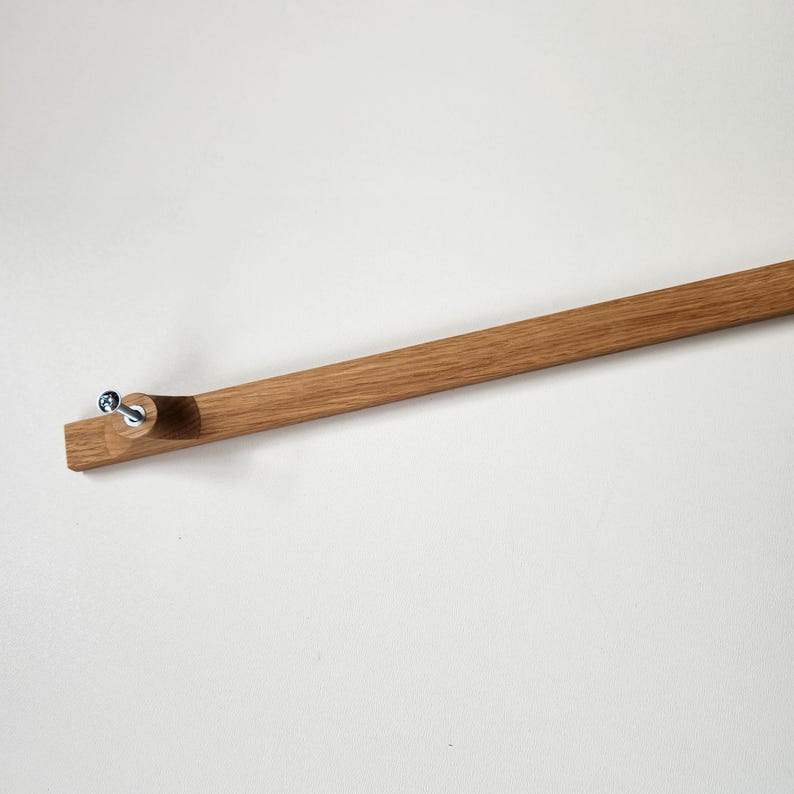 May include: A wooden picture frame component, featuring a natural wood grain finish. The frame has a rectangular end with pre-drilled holes for screws. The frame is designed to hold a picture or artwork.