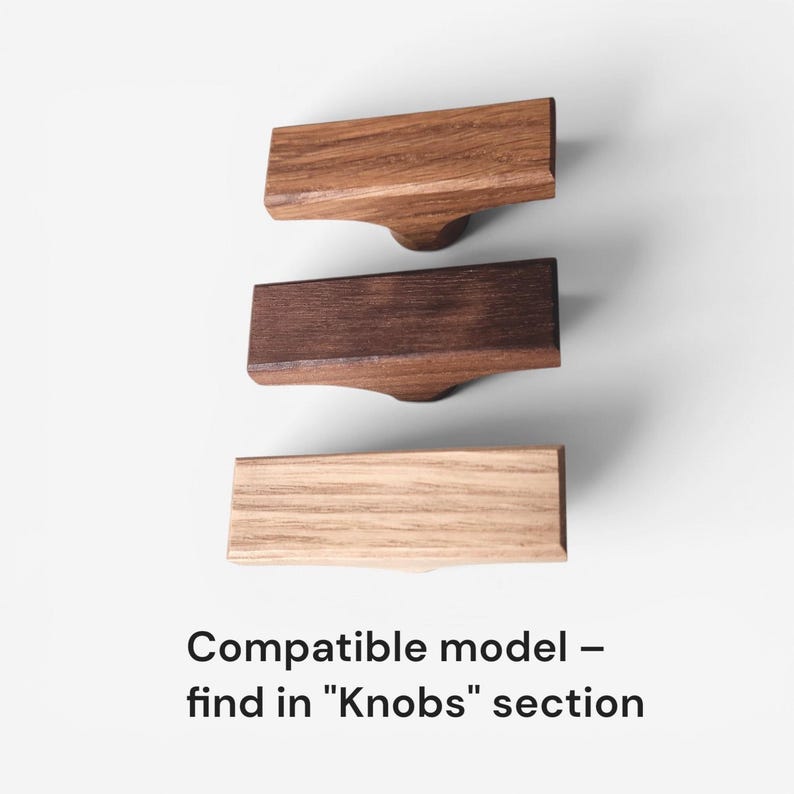 May include: Three wooden cabinet knobs in varying shades of brown, arranged vertically against a white background. The knobs have a rectangular top and a rounded base. Text at the bottom reads "Compatible model - find in "Knobs" section."
