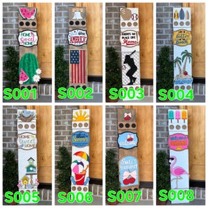 May include: A collection of wooden welcome signs with various summer and patriotic themes. Designs include a watermelon, American flag, baseball, beach scene, birdhouse, sun, beach bucket, and flamingo. Each sign is rectangular and features decorative elements and text.